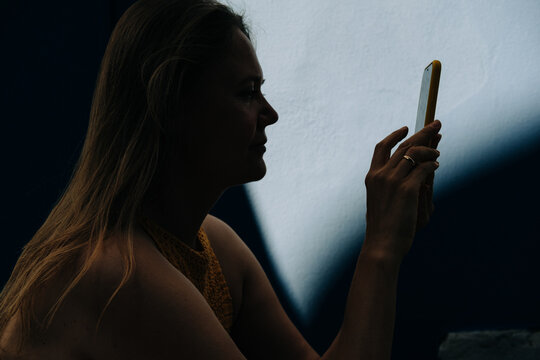 Silhouette of a Woman Using a Smartphone