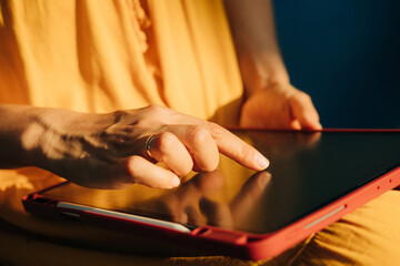 Close up of female hand on tablet computer in sunlight