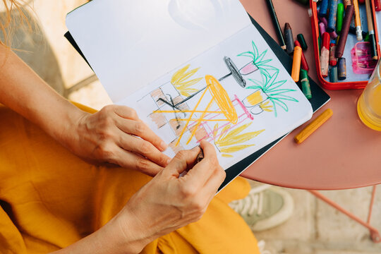 Top view of illustrator's hands making drawing in a sketchbook
