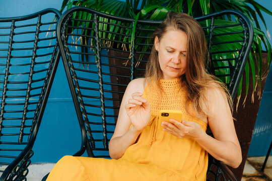 Woman resting in a chair using mobile phone