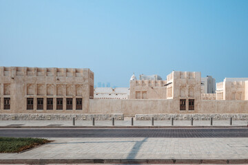 Fototapeta premium The exterior of a traditional Middle Eastern mud brick building with a row of arched windows of Domes Mosque in Doha, Qatar.