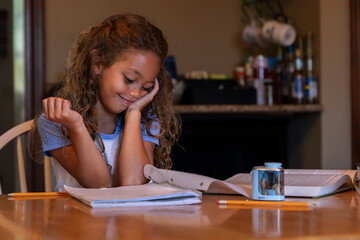 Girl doing homework at kitchen table