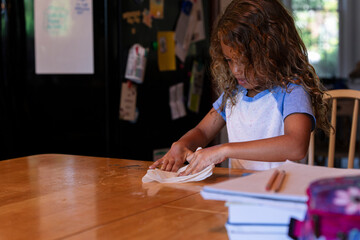 Young Girl Cleaning Kitchen Table After Project
