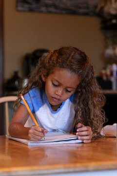 Girl doing homework at kitchen table