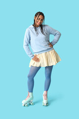 Naklejka premium Beautiful young African-American woman in roller skates with dreadlocks on blue background