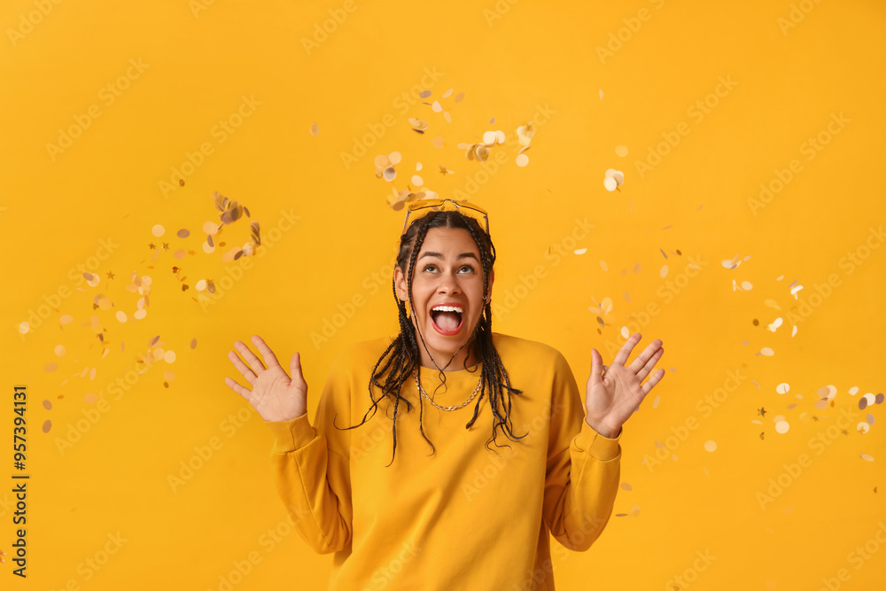 Sticker surprised young african-american woman with dreadlocks and confetti on yellow background