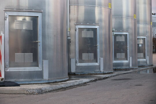 Four large metal tanks with doors on them