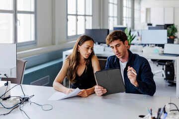 Two focused business people working together in office