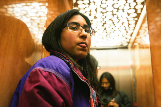 Personsticking out their tongue in elevator