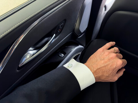 Self Portrait Hand of man in Luxury suit with cuff Link inside car 