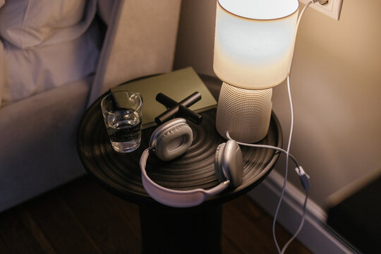 Still life photo of objects on metal nightstand standing near bed 