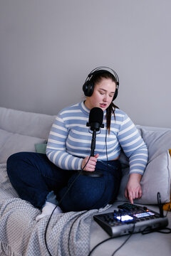 Plus size podcaster making sound adjustments for live broadcasting 