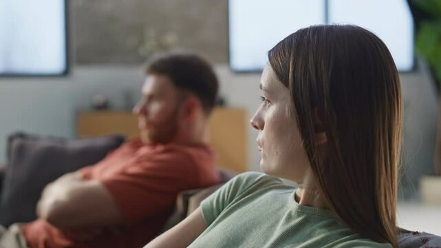 Upset wife offended husband showing dissatisfaction at home sofa closeup.