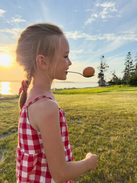 Young Girl with egg on spoon at party fun contest 