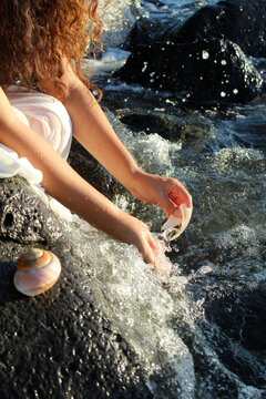 Woman in White Dress Gathering Shells