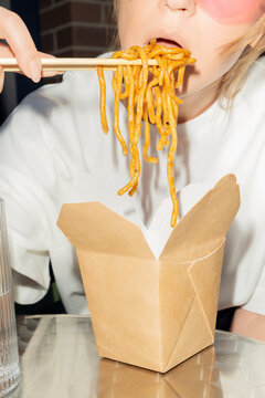 Close-Up of Eating Noodles with Chopsticks from Takeout Box