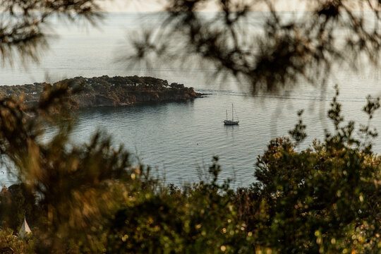 Scenic View of Sailboat and Rocky Coastline

