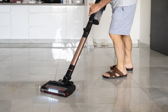 Senior Man Cleaning Floor with Cordless Vacuum