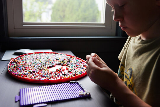 Little boy doing perler beads