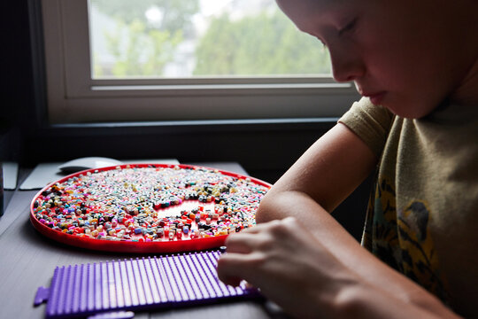 Little boy doing perler beads
