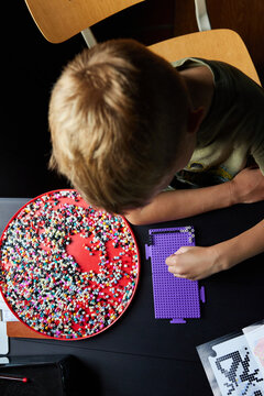 Little boy doing perler beads