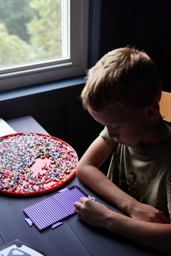 Little boy doing perler beads