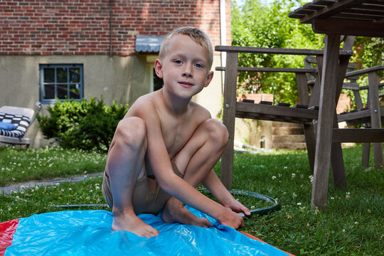 Little boy setting up waterslide