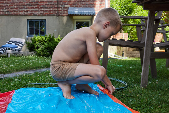 Little boy setting up waterslide