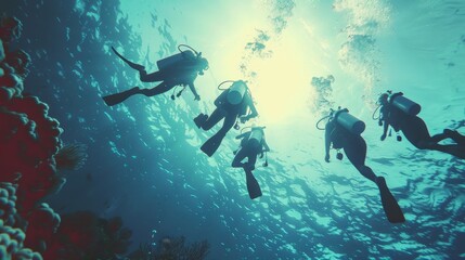 Fototapeta premium A group of four scuba divers are swimming in the ocean