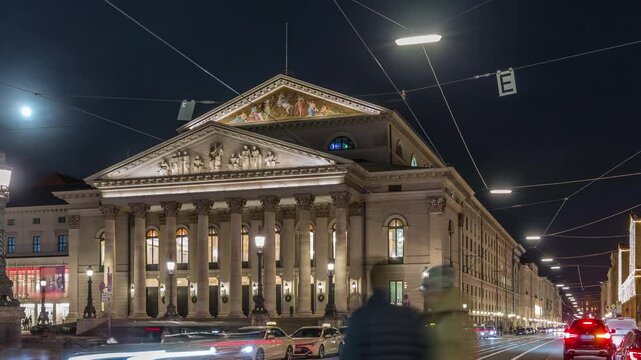 Munich National Theatre or Nationaltheater on the Max Joseph square night timelapse. Traffic on the street with trams and taxi parking. Historic opera house, home of the Bavarian State Opera. Germany