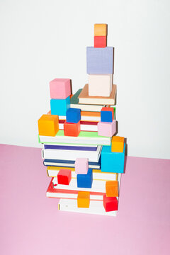 Colorful stack of books and geometry cubes and hard direct flashlight