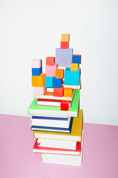 Colorful stack of books and geometry cubes and hard direct flashlight