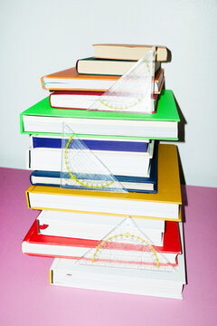 Colorful books and math set square rulers on office business desk