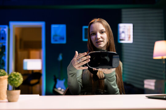 Tech influencer filming sponsored content, unboxing newly released VR glasses product to make fans buy it. Entertainer amazed by product, presenting impressive virtual reality headset to subscribers