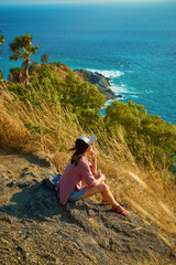 A girl is sitting on the background of a tropical bay