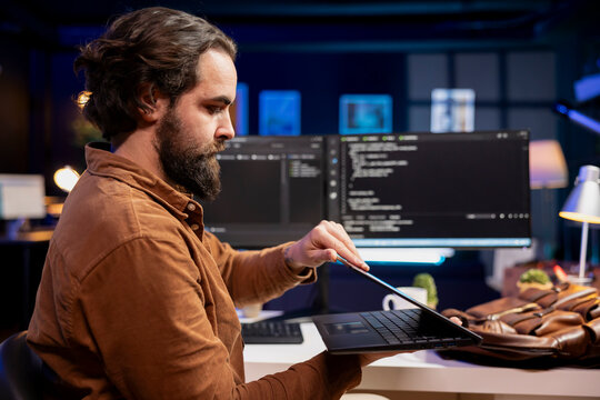 Programmer closing laptop, ready to go home after designing and developing software applications. IT professional packing notebook after implementing and maintaining company systems