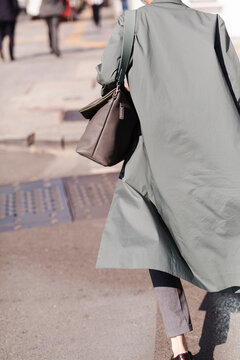 Person Walking On Sidewalk In Stylish Coat And Bag