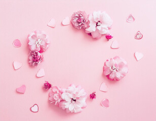 Obraz premium Romantic Valentine's Day Wreath: Pink Flowers and Hearts on Pastel Pink Background
