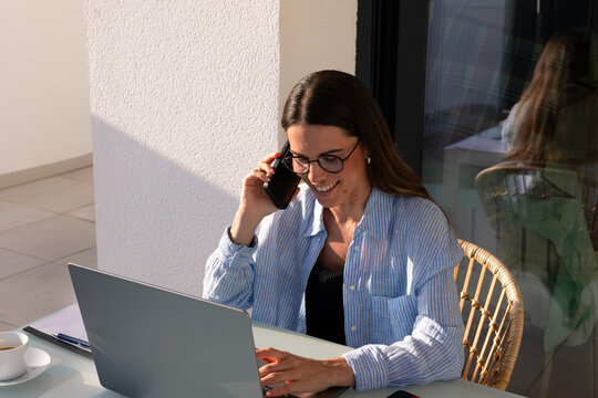 Female freelancer enjoys to take a business call from her house