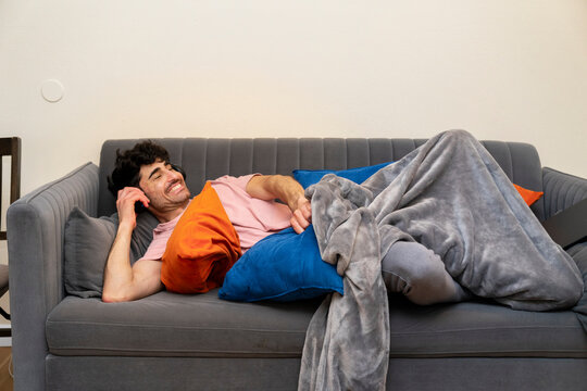 Laughing headphones chilling on sofa