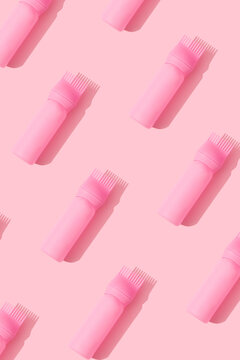 Pink hair oil applicator neat pattern on a pastel pink background.