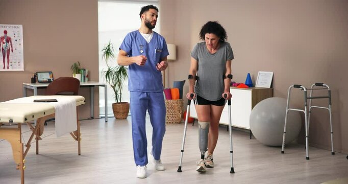 Physical therapy, crutches and woman with prosthetic leg for walking, rehabilitation or help. Amputee patient, nurse or person with disability in clinic for medical, healthcare or talking for support