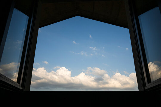 View of Blue Sky and Clouds through an Open Window