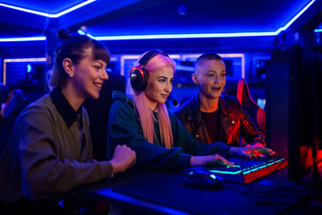Gamer girl with headset playing a video game while her friends cheering © Zamrznuti tonovi
