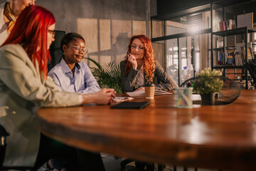 Interracial businesswomen sitting at conference room and collaborating
