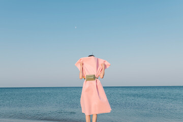 Woman in Pink Dress Facing the Ocean at the Beach