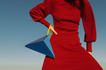 Fashion Model In Red Dress Posing With Unique Geometric Handbag