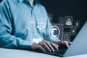 Copyright or patent concept. Businessman working on a laptop with digital icons representing intellectual property and digital copyright law. Trademark license, copyleft, Rights symbol, Piracy crime,
