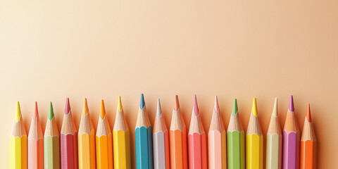 colored pencils and various stationery items, like small notebooks, against an isolated pastel cream background