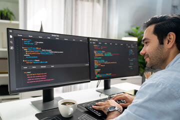 Concentrating in smart IT developer working software development coding on two pc screen, creating...